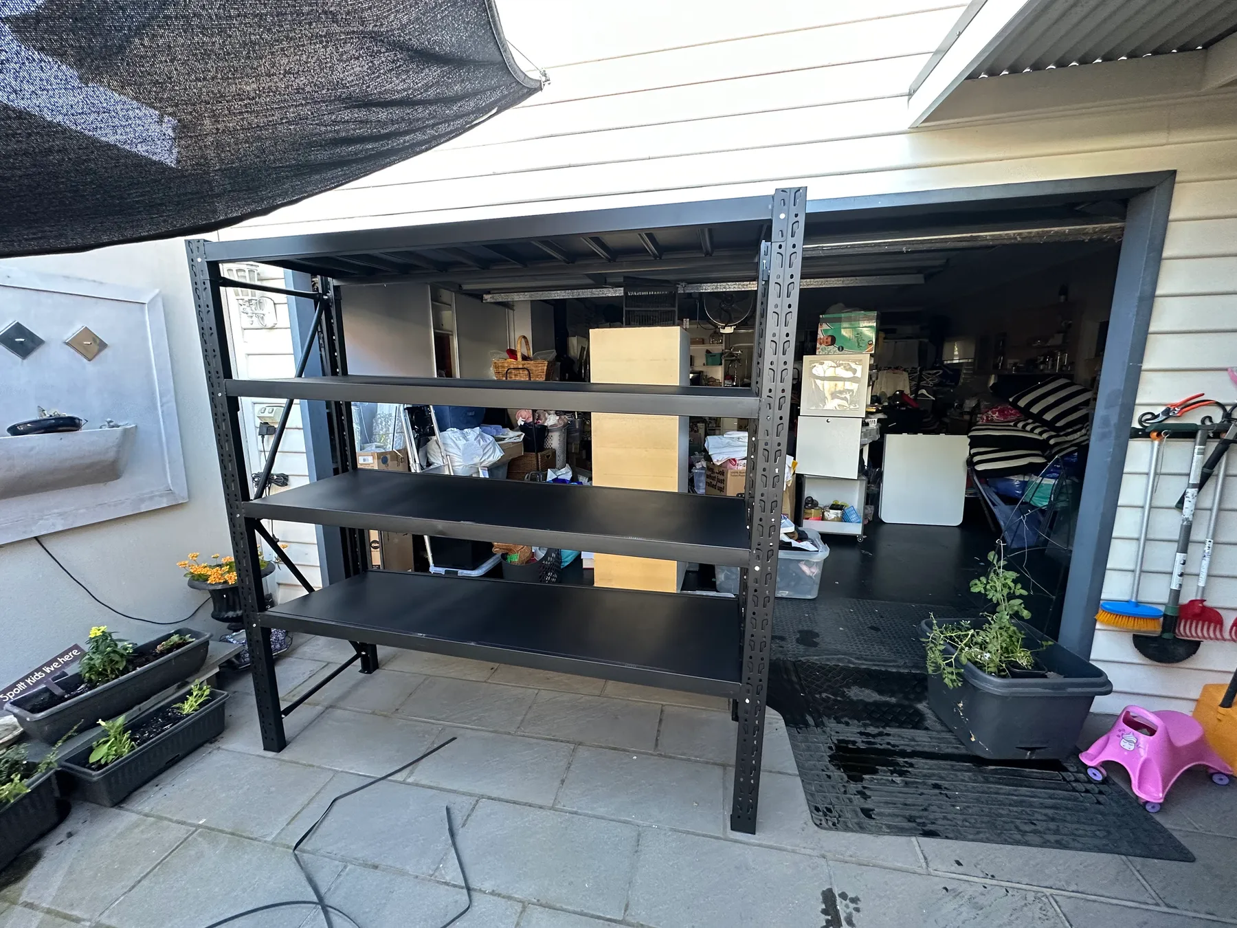 Black metal shelves in busy garage space