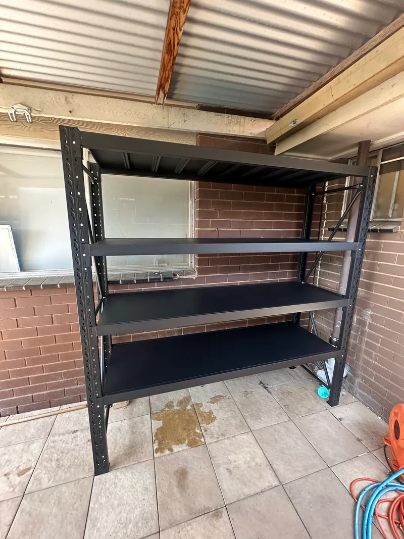 Black metal shelves in outdoor brick area