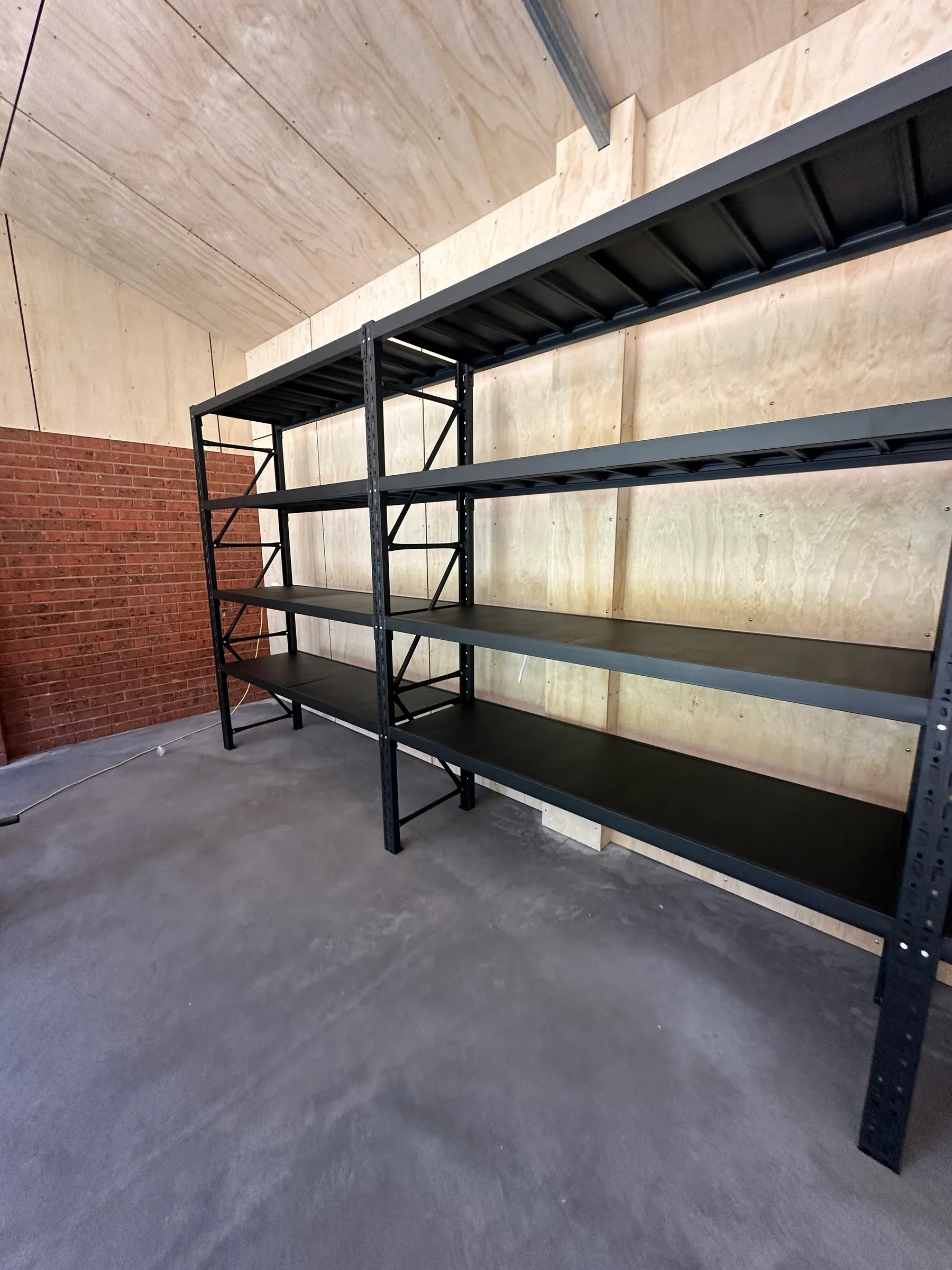 Empty black shelves against wooden and brick walls
