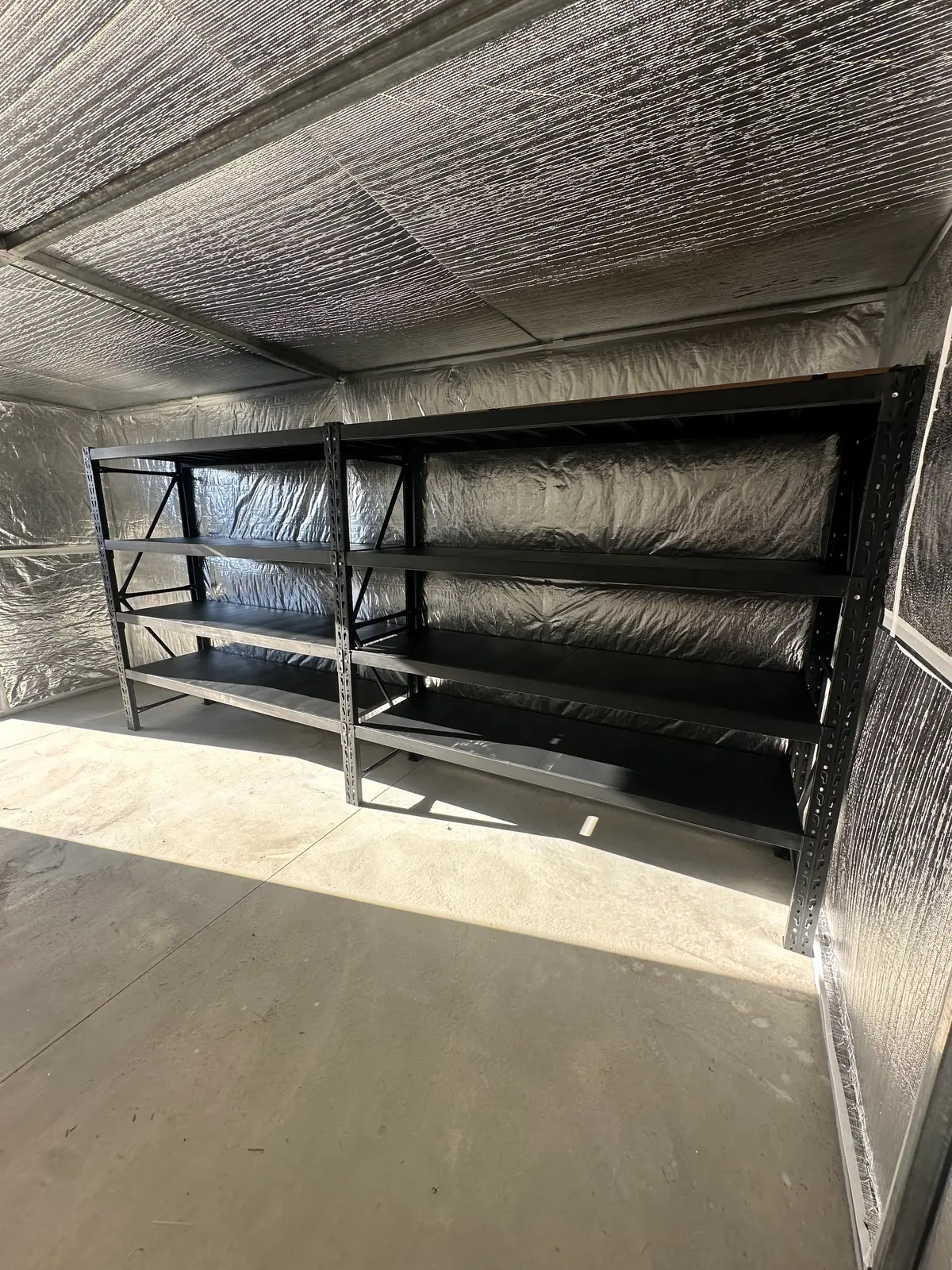 Empty black shelves in shiny metal room