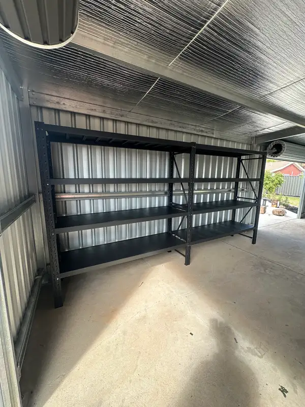 Empty metal shelves in corrugated metal shed