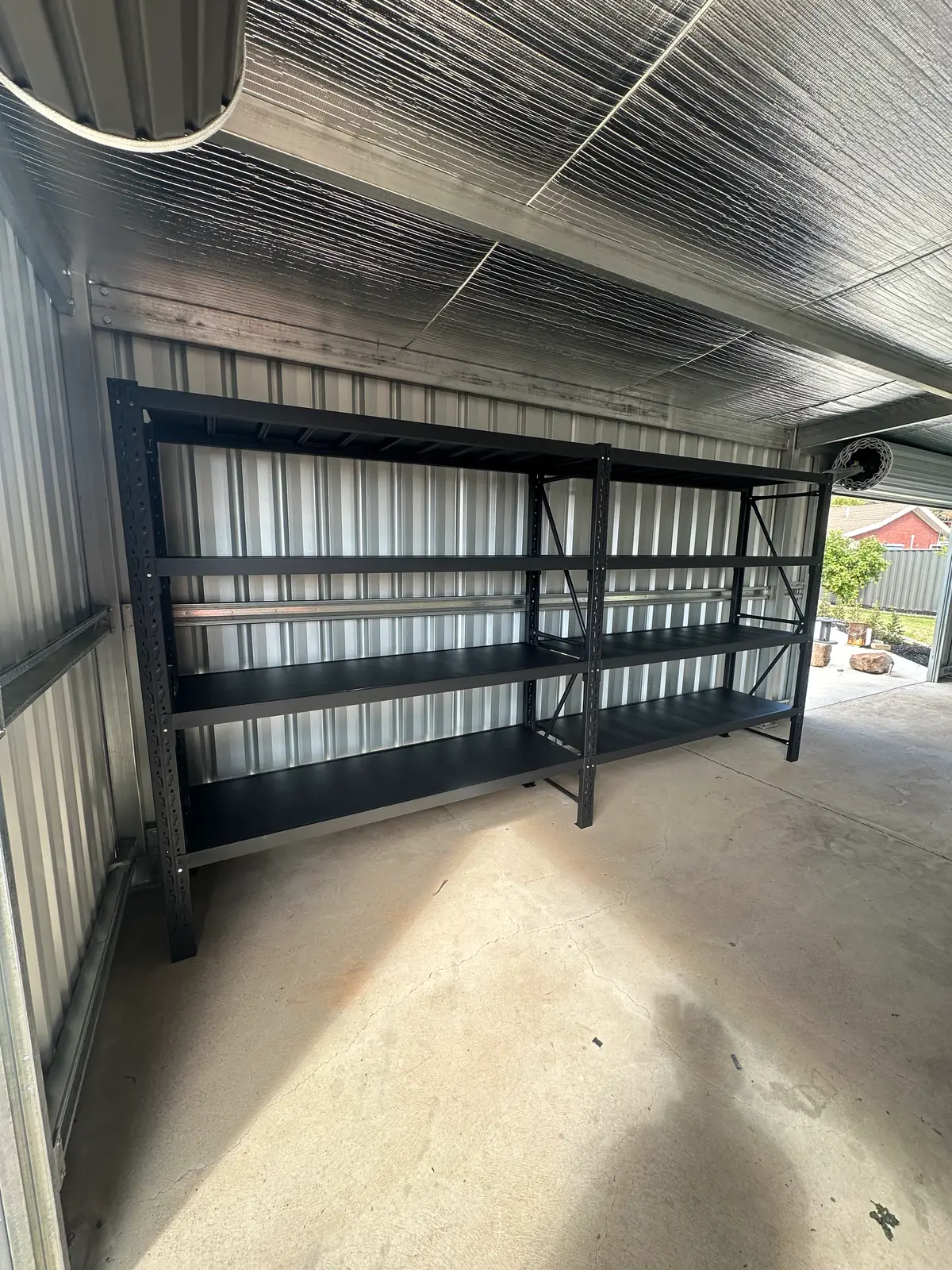 Empty metal shelves in corrugated metal shed