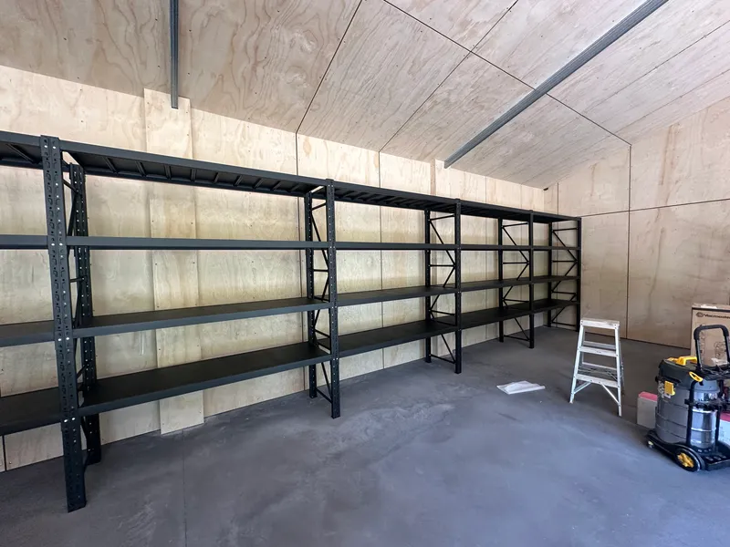 Empty storage shelves in unfinished wooden room
